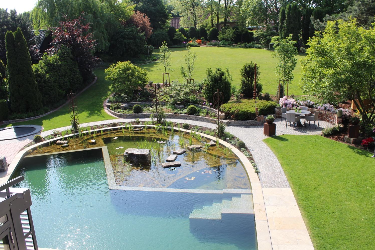 Ein großes individuelles Becken im Garten mit Hanglage für die ganze Familie im Münsterland