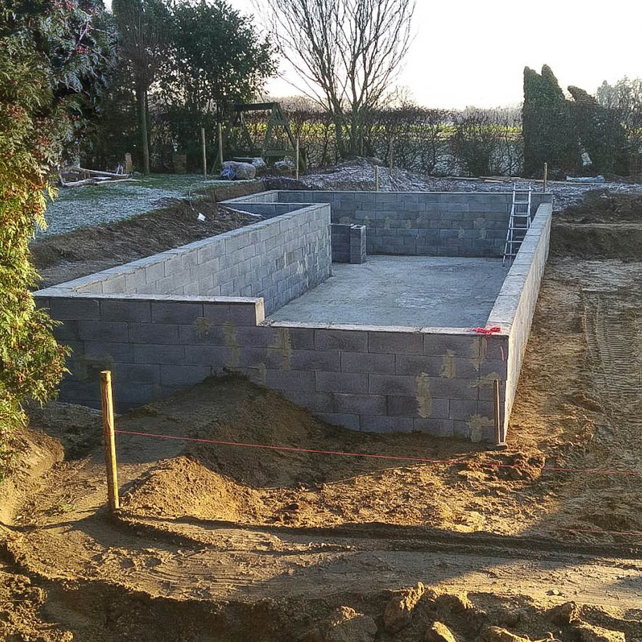Die Grundmauer eines Schwimteiches, begleitet durch die Bauanleitung von Garten Bitters.