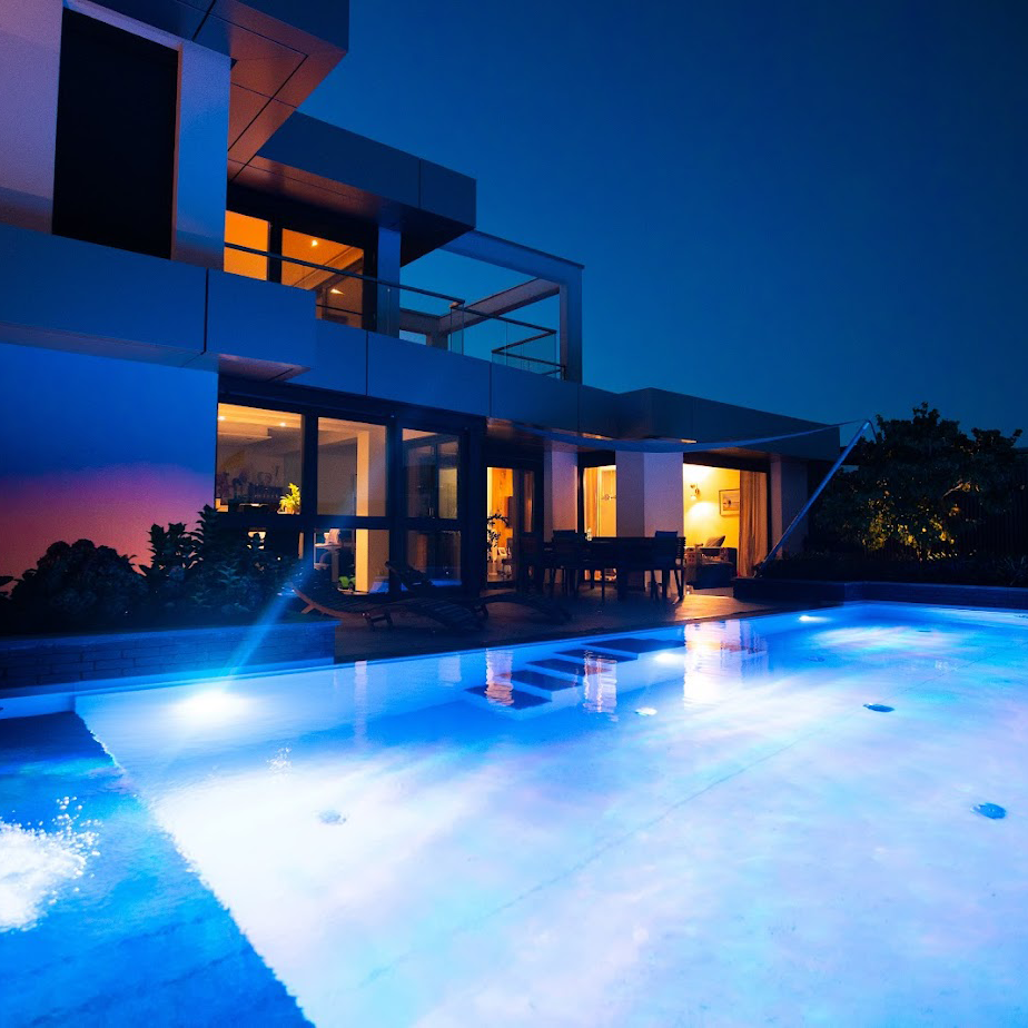 Ein Folienpool von Garten Bitters vor einem Haus in blauem Licht.