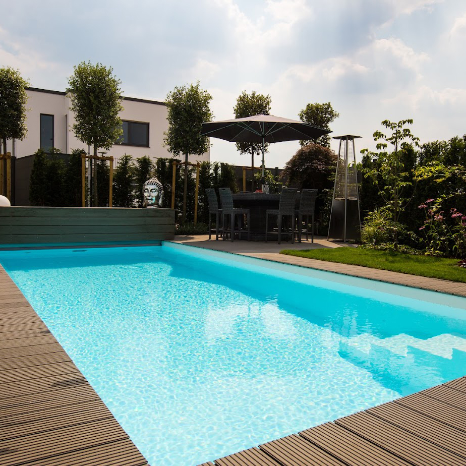 Ein Fertigbecken von garten Bitters mit Treppe und einem Sonnenschirm im Hintergrund.