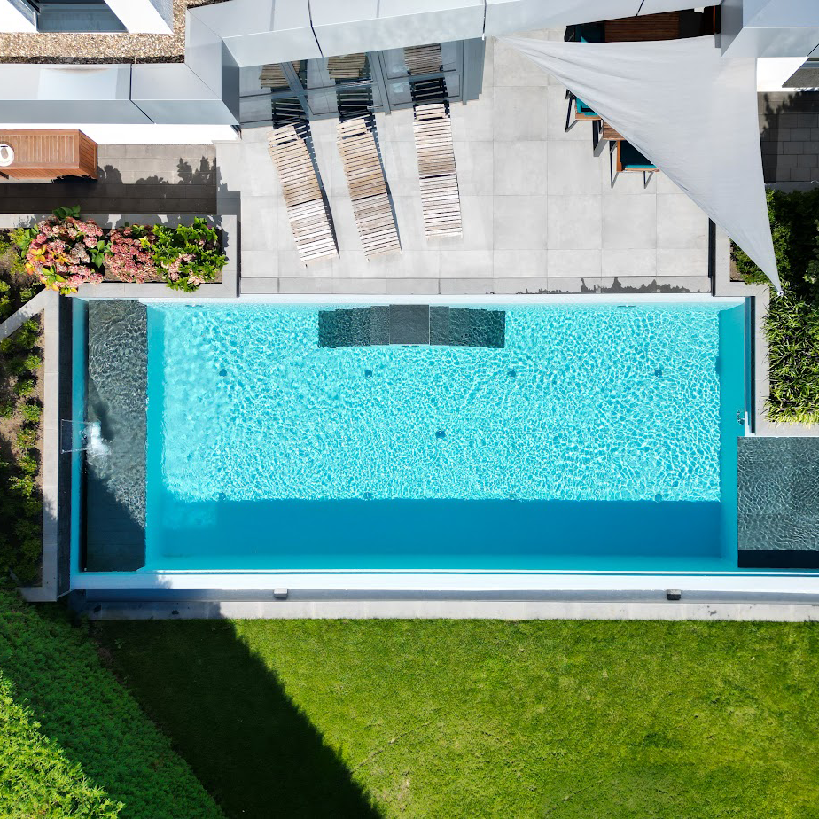 Ein Biotop-Schwimmteich, gebaut von Garten Bitters mit doppelter Zugangstreppe und Wasserfall zur Reinigung.